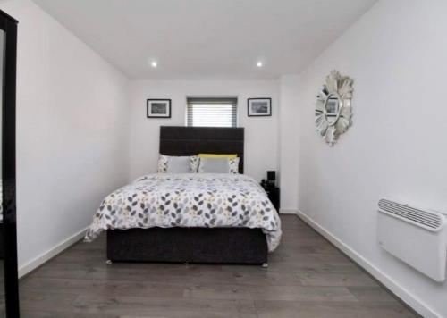 利物浦坎贝尔广场3号公寓的一间卧室设有一张床和白色的墙壁