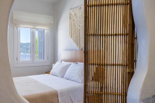 斯科派洛斯Aurora Apartment - Skopelos的一间卧室设有一张床和一个窗口
