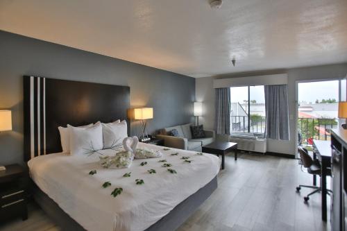亨廷顿海滩城市冲浪贝斯特韦斯特酒店的酒店客房,配有一张带鲜花的大床
