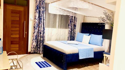 蒙巴萨The Pontoons Nyali A103的一间卧室配有蓝色和白色的床
