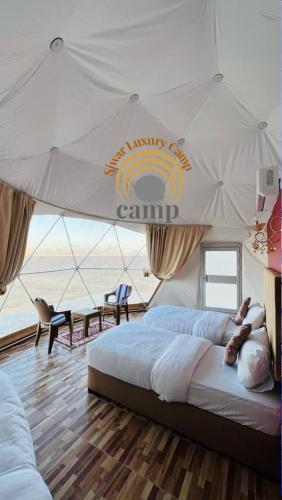 瓦迪拉姆Siwar Luxury Camp的一间卧室设有两张床和天篷