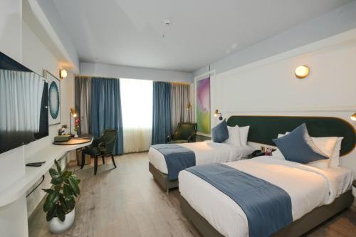 KondottiPushpak Grande的酒店客房配有两张床和一张书桌