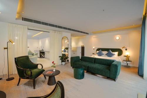 KondottiPushpak Grande的客厅配有绿色沙发和床。
