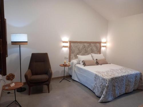 A XesteiraVeiga Mariña的一间卧室配有一张床、一把椅子和一盏灯