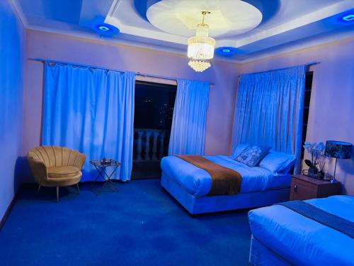 姆巴巴内GoldenWays Motel的一间卧室配有一张床、一把椅子和蓝色的灯光