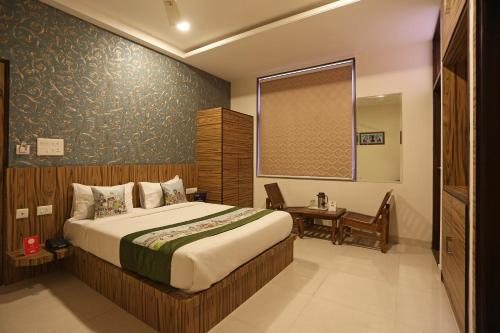 新德里Hotel Global Radiance plaza Delhi Airport的一间卧室配有一张床、一张桌子和一个窗户。