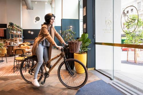 奥克兰voco Auckland City Centre, an IHG Hotel的一位在商店骑着自行车的女人