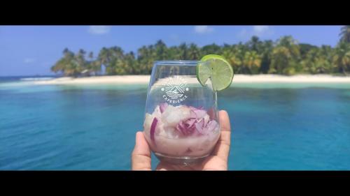 NiagalubirLuxury and Gourmet Catamaran Slow Travel Experience的喝着酒的人,喝着石灰和沙滩