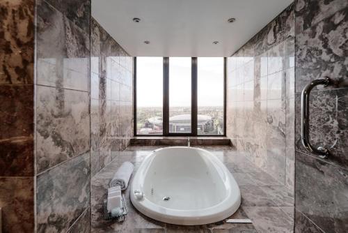 阿德莱德阿德莱德洲际酒店的带浴缸的浴室和大窗户
