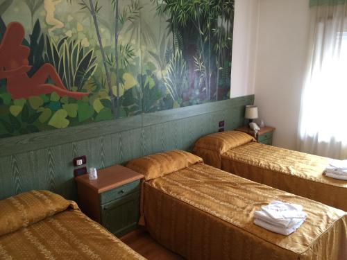 San Vito di LeguzzanoHotel Ristorante Il Pirata的墙上画画的房间的三张床