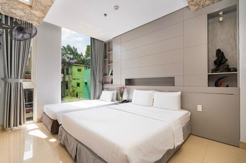 胡志明市Lucky Star Hotel Nguyen Trai Q5的配有窗户的酒店客房内的两张床