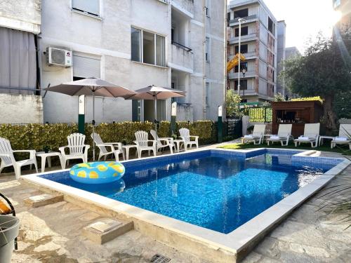 布德瓦Apartments Pribilovic的一个带椅子和遮阳伞的游泳池