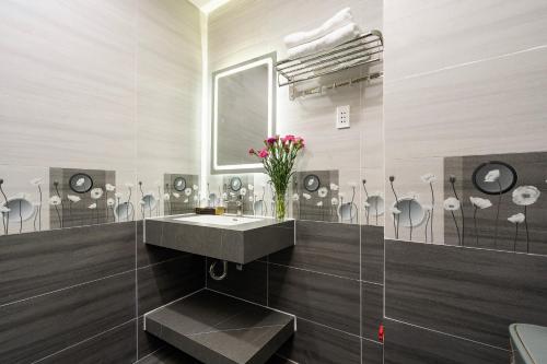 胡志明市Lucky Star Hotel Nguyen Trai Q5的一间带水槽和花瓶的浴室