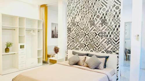 芹苴MIDMOST Villa Hotel的卧室配有一张白色大床和墙壁