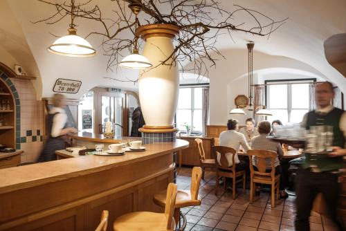 哈特贝格泽姆布劳豪斯餐厅旅馆的一间设有酒吧的餐厅,有的人坐在桌子旁