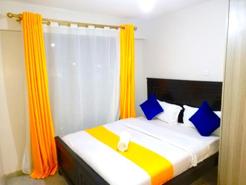 内罗毕Rew Apartment的一间卧室配有蓝色和橙色窗帘的床