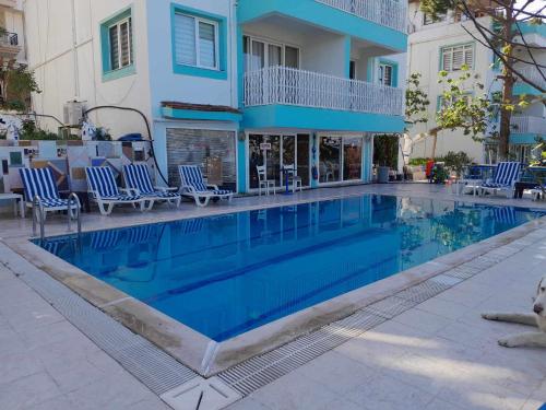 库萨达斯ASIA APART HOTEL的一座带蓝色椅子的游泳池和一座建筑
