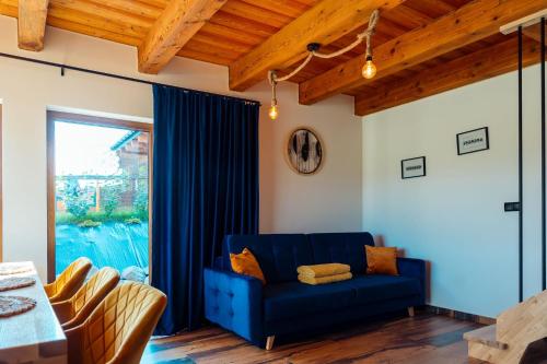 加沃尔金卡Kasztanowe Zacisze的客厅设有蓝色的沙发和窗户。
