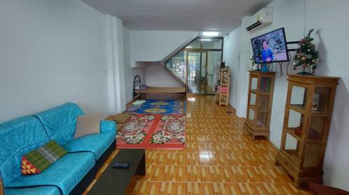 Ban Tha SaeClassic Home Stay Hatyai的客厅设有蓝色的沙发和楼梯。