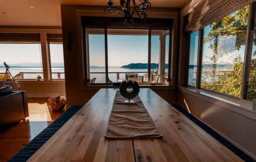 埃德蒙兹Stunning House with Views of Puget Sound! Ideal for Family Reunions的客厅设有木桌和窗户