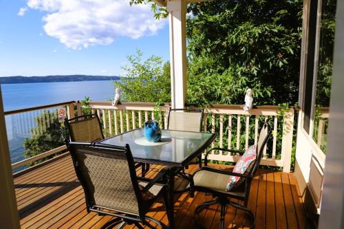 埃德蒙兹Stunning House with Views of Puget Sound! Ideal for Family Reunions的水景门廊上的桌椅