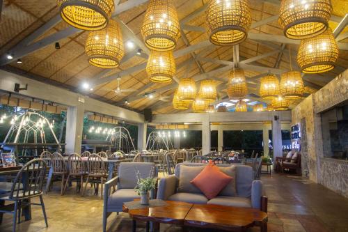 长滩岛Fairways and Bluewater Boracay的餐厅设有桌椅和吊灯。