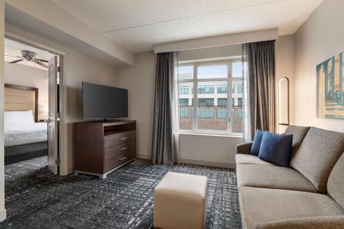 华盛顿华盛顿市中心希尔顿惠庭套房酒店的酒店客房设有沙发、电视和床。
