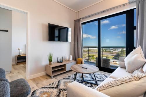 开普敦Top Floor 2 Bedroom Apartment Ocean Views, parking的客厅配有沙发和桌子