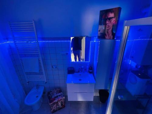 Appartamento a Udine con doccia idromassaggio的浴室拥有蓝色的灯光,镜子里的人