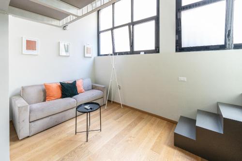 米兰Modern Loft in Porta Venezia - hosted by Sweetstay的客厅配有沙发和桌子