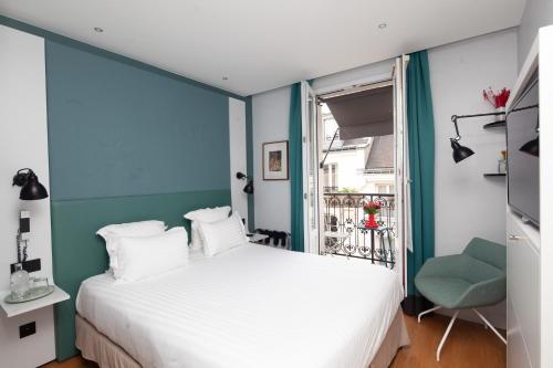 巴黎旺多姆圣日耳曼酒店的卧室配有白色的床和蓝色的墙壁