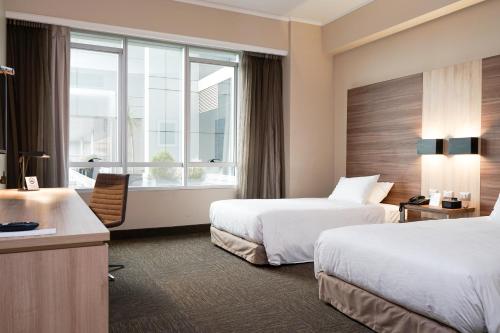 康塞普西翁Mercure Concepcion的酒店客房设有两张床和窗户。