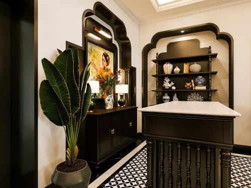 胡志明市Milestone Inn Hotel的浴室设有黑色橱柜和盆栽植物