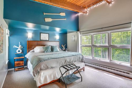 Private Delevan Cabin Rental Lake Access with Dock!的卧室拥有蓝色的墙壁,设有一张床和窗户。