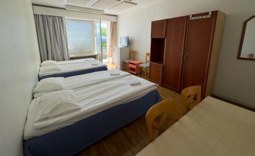 图尔库B&B Retro - Guesthouse Kupittaa的一间卧室配有一张床、一张书桌和一个窗户。