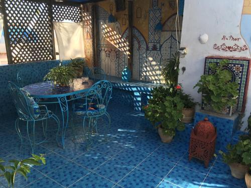 艾西拉HATHOR ,Casa marroquí con dos terrazas en la Medina antigua , ideal parejas!! WIFI!!的天井配有桌椅和盆栽植物