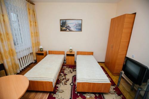 克列缅丘格Hotel Uyut的一间设有两张床和电视的客房
