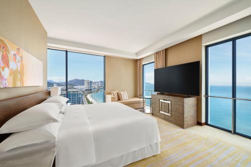 芽庄Sheraton Nha Trang Hotel & Spa的配有一张床和一台平面电视的酒店客房