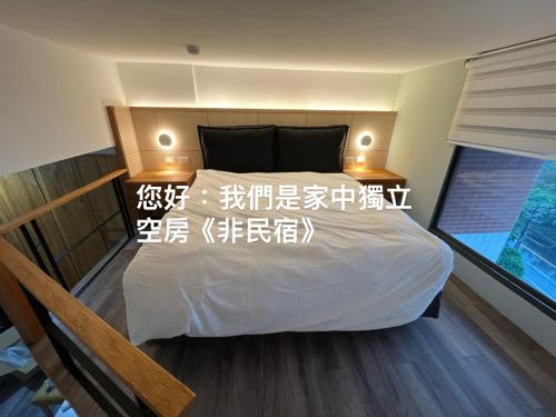 万里区Loft inn的卧室配有白色的床,上面写着