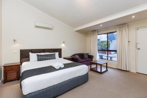 蒂默特阿玛鲁汽车旅馆的卧室配有床、椅子和窗户。