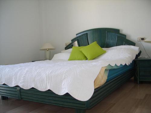 米哈斯科斯塔APT EL FARO ARKADIA BEACH MIJAS COSTA Marvellous Frontbeach with stunning seaviews and historic lighthouse的绿色的床,配有白色床单和绿色枕头