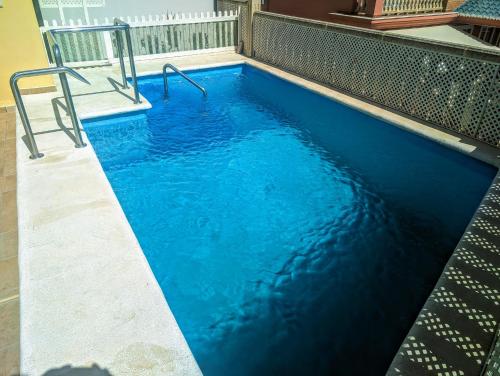 托雷德尔马尔Viña Home的大楼内的一个蓝色海水游泳池