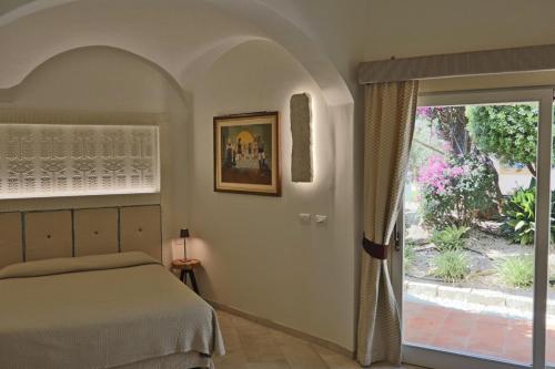 卡尔德杜Corte Bianca - Adults Only & SPA - Bovis Hotels的一间卧室设有一张床和一个滑动玻璃门