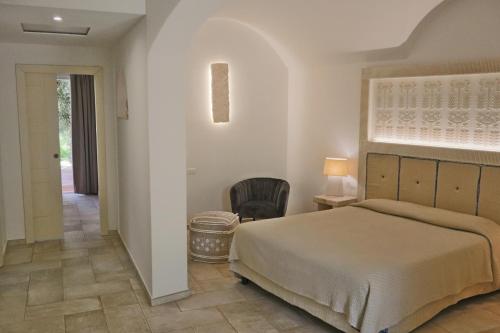卡尔德杜Corte Bianca - Adults Only & SPA - Bovis Hotels的一间卧室配有一张床和一把椅子