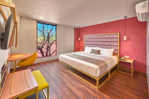 瓦哈卡市City Centro by Marriott Oaxaca的一间卧室设有一张红色墙壁的大床