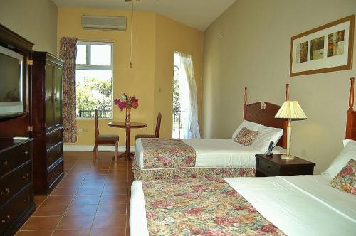 拉纳韦贝Guest House Villa Mishkan的酒店客房设有两张床和一张桌子。