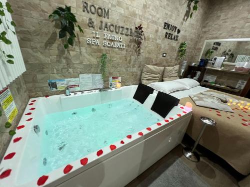斯卡法蒂Il FAUNO - Suite & SPA的配有床的房间的大浴缸