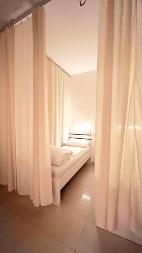 迪拜WeStay Ladies Hostel的白色窗帘的房间的一张床位