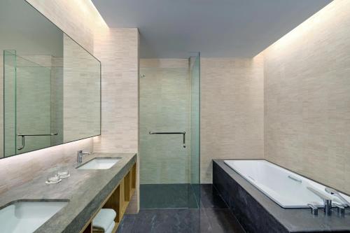 雅加达Aloft South Jakarta的一间带两个水槽和玻璃淋浴间的浴室