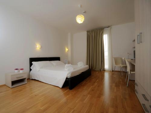 阿雷佐Hotel Arezzo ASC的卧室配有白色的床,铺有木地板
